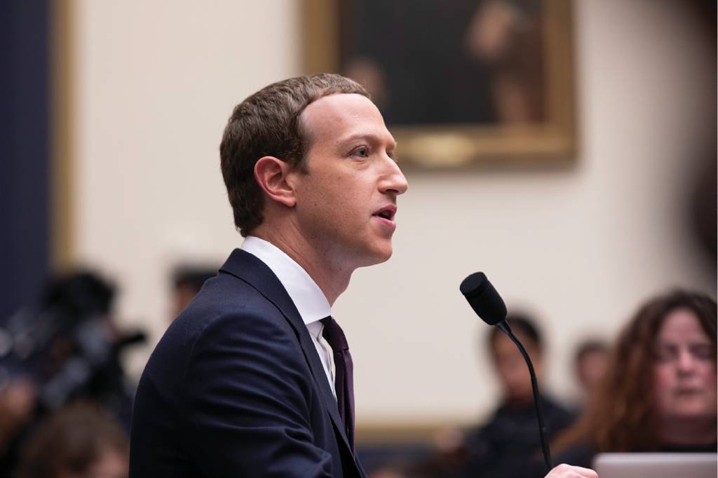 SA284_FUNDAMENTOS_4 Zuckerberg, de perfil. Ele veste terno e está sentado em frente a um microfone.