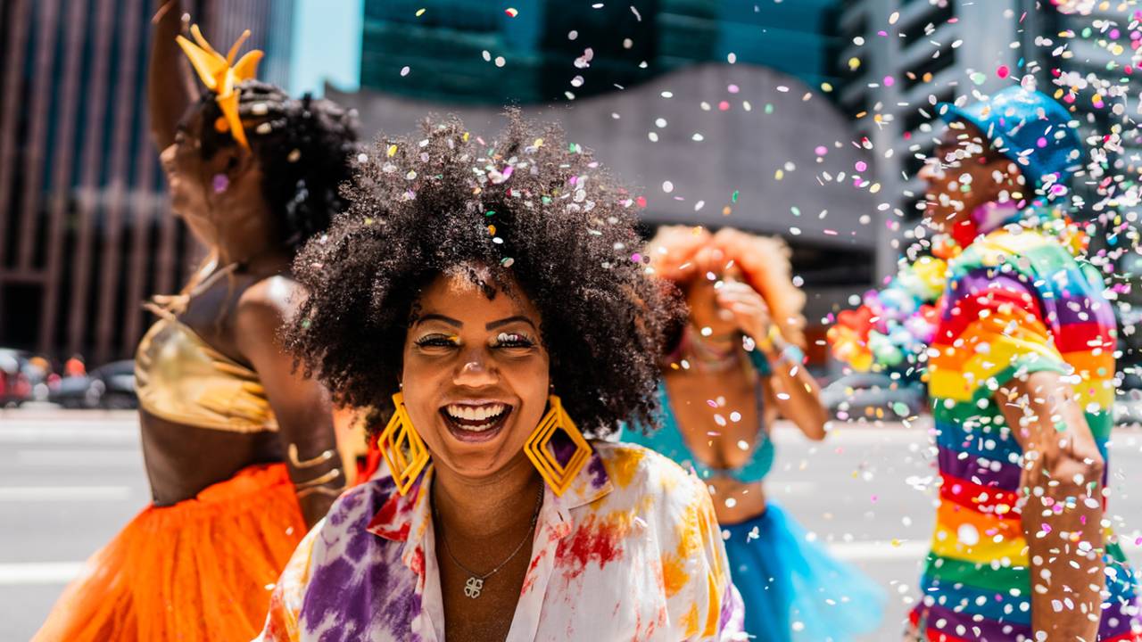 Retrato de uma mulher adulta se divertindo com os amigos no carnaval de rua.